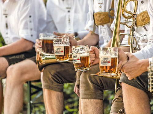 Berg BrauereiWirtschaft Blasmusik Personen halten ein Bier und ein Musikinstrument