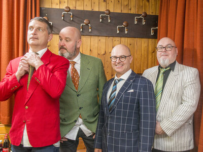 Vier Männer in Anzügen posieren