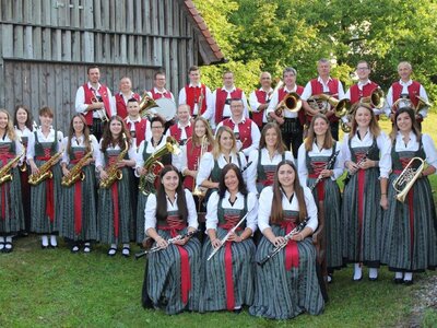 Eine Gruppe von Musikanten sitzen auf einer Wiese