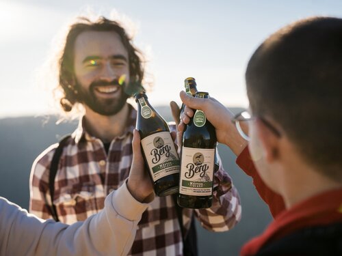 Drei Personen stoßen mit Berg Märzen an