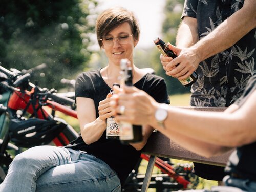Fahrradfahrerin öffnet und trinkt Maria-Anna 