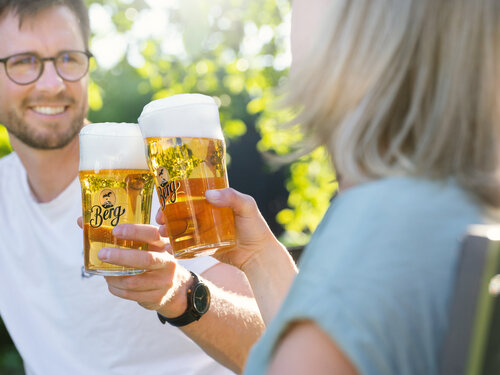 Ein Mann und eine Frau stoßen mit Bier an