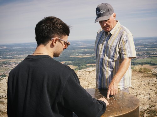 Zwei Menschen begutachten eine Steintafel
