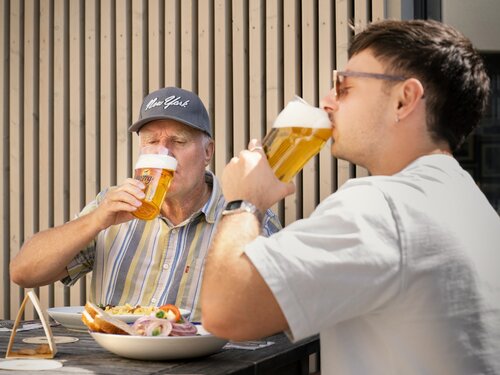 Zwei Personen trinken gemeinsam ein Bier
