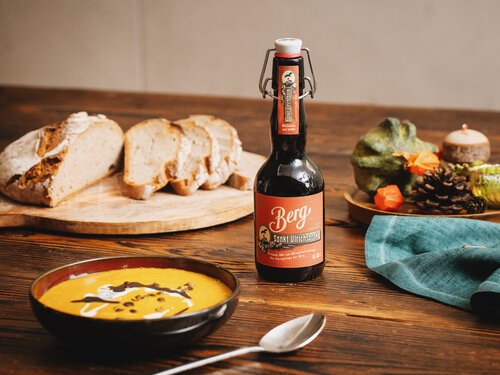 Ein Bier steht auf einem Tisch mit Brot und Suppe