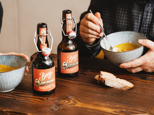 Zwei Bierflaschen stehen auf einem Tisch mit Suppen