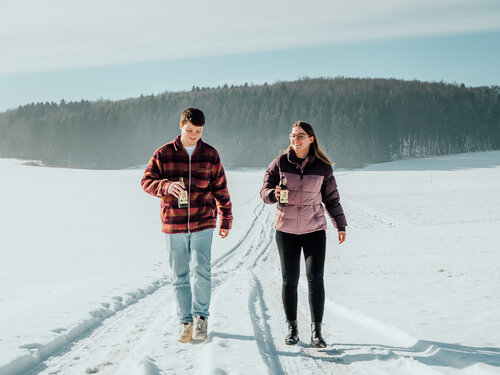 Zwei Menschen wandern gemeinsam im Schnee