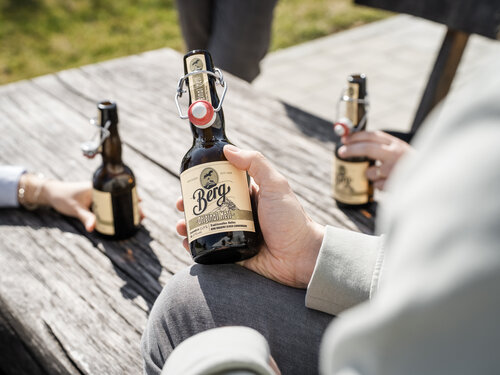 Offene Bierflasche in der Hand beim Feierabendbier