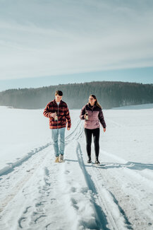 Zwei Menschen wandern gemeinsam im Schnee