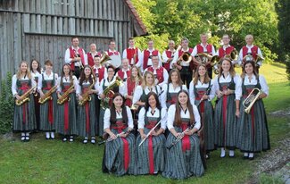 Eine Gruppe von Musikanten sitzen auf einer Wiese